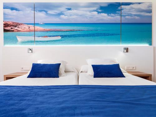 a bedroom with a bed with two blue pillows at Playas Ca's Saboners in Palmanova