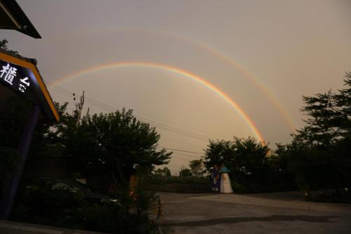 a rainbow in the sky over a parking lot at Junyi Landscape Villa in Renai