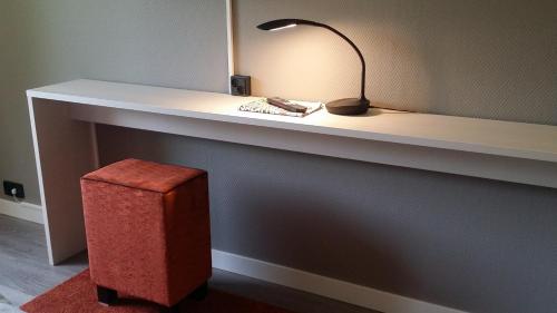 a desk with a lamp and a stool under it at Hotel Kauppi in Tampere