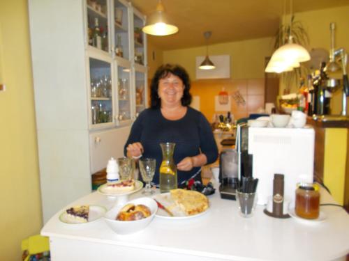a woman standing behind a counter with food on it at Penzión Eva in Stará Voda