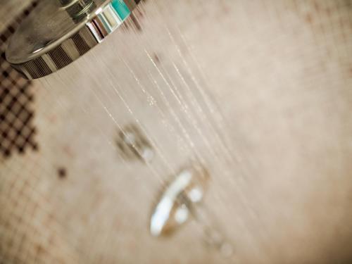 a shower head with water coming out of it at Hotel Alpenjuwel in Melago