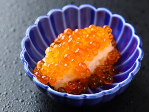 a blue and white bowl filled with orange caviar at Dormy Inn Tokyo Hatchobori - Natural Hot Spring in Tokyo