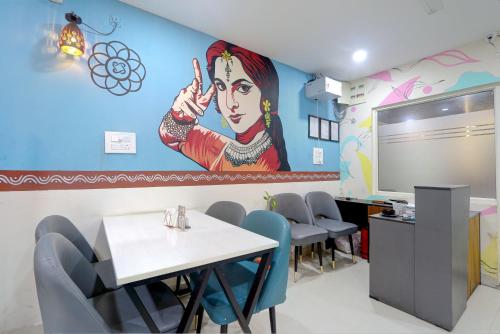 a dining room with a large painting on the wall at Hotel The Cinco Bliss Gachibowli in Gachibowli
