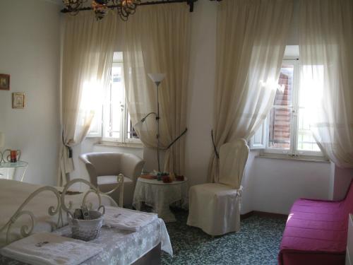 a living room with a bed and two windows at B&B Casa Delle Rose in Antria