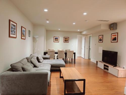 a living room with two couches and a dining room at Bright 3-Bedroom Basement Suite with Separate Entrance in Burnaby