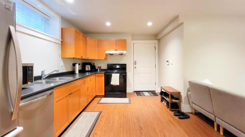 a small kitchen with wooden cabinets and a sink at Bright 3-Bedroom Basement Suite with Separate Entrance in Burnaby