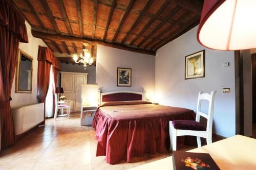 a bedroom with a bed and a table and chairs at Antica Locanda San Leonardo 1554 in Ghivizzano