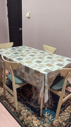 a table with two chairs and a table with a tablecloth at D'Homestay Merinding Trail WP Labuan in Labuan