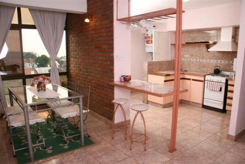 a kitchen with a glass table and a brick wall at Edificio Nicolas y Marcelo Siry in Posadas