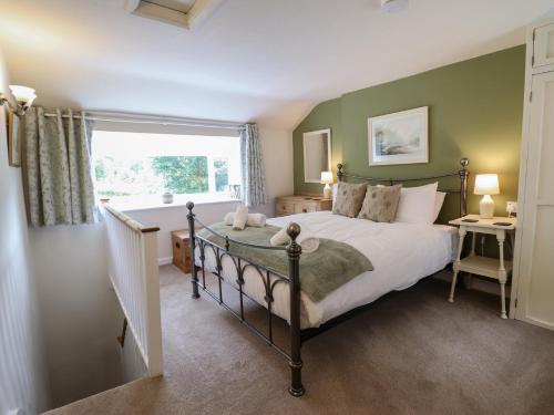 een slaapkamer met een groot bed en een raam bij Riverside Cottage in Caernarfon