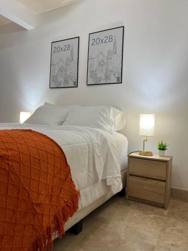 a bedroom with a bed and two pictures on the wall at Descanso Frente al Consulado in Hermosillo