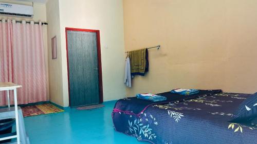 a room with a bed and a door in it at Capital O 91191 Chalet Cd Impiana in Kulim