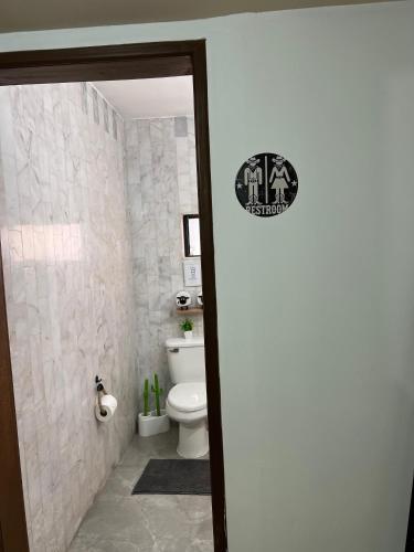 a bathroom with a toilet and a toilet paper dispenser at Descanso Frente al Consulado in Hermosillo
