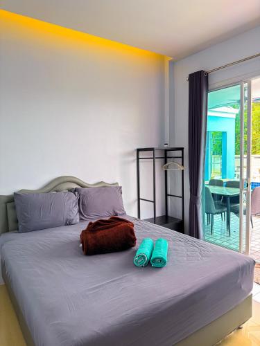 a bedroom with a bed with blue slippers on it at BAN SINGH TO Poolvilla in Cha Am