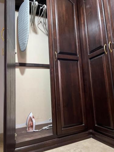 a closet with a wooden door and a pair of shoes at Descanso Frente al Consulado in Hermosillo