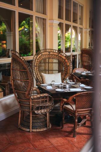 a dining room with a table and chairs and windows at Sofitel Angkor Phokeethra Golf & Spa Resort in Siem Reap