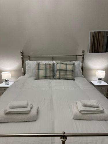a white bed with towels on it with two lamps at Luxury King Room In the Heart Of Edinburgh in Edinburgh