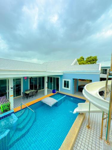 a large swimming pool with a house at BAN SINGH TO Poolvilla in Cha Am