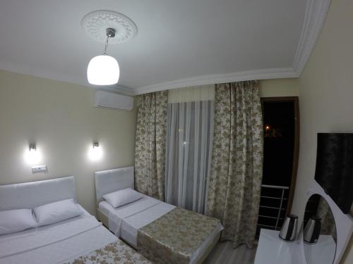 a bedroom with two beds and a table and a window at Pınar Vintage House in Pamukkale