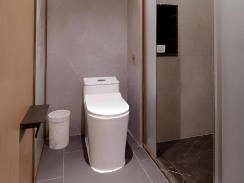 a bathroom with a white toilet in a room at ZMAX Hotels Shenzhen Lianhuacun Metro Station in Shenzhen