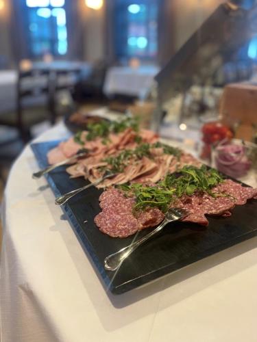a plate of food with meat and vegetables on a table at Filskov Kro in Grindsted