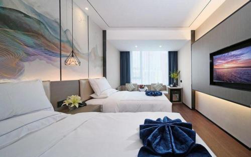 a hotel room with two beds and a flat screen tv at Xiamen Seashine Lakeview Hotel in Xiamen