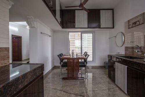 a kitchen with a table with chairs and a sink at Sree Bharat Apartment in Coimbatore