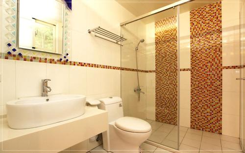 a bathroom with a toilet and a sink and a shower at Color Sea B&B in Dawu