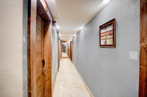 a hallway with blue walls and a picture on the wall at Super Townhouse Prayagraj Central Bus Terminal Formerly Hotel Four View in Civil Lines