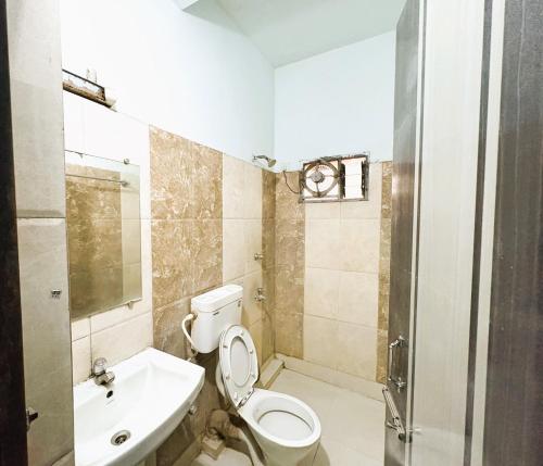 a bathroom with a toilet and a sink at Aditi Residency New Digha Near Sea Beach in Digha