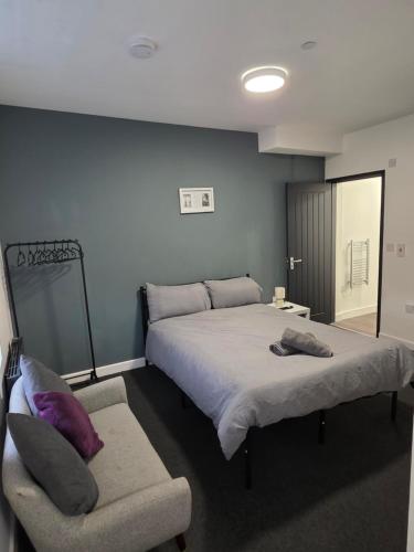 a bedroom with a large bed and a chair at Cosy Studio City Centre in Wolverhampton