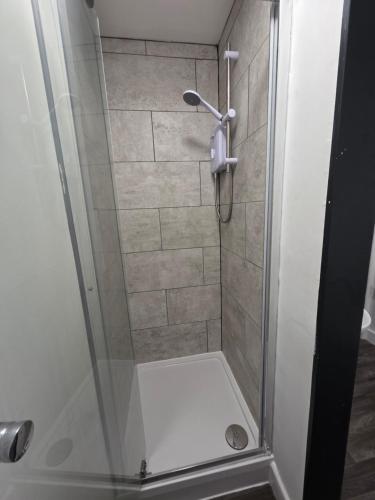 a shower with a glass door in a bathroom at Cosy Studio City Centre in Wolverhampton