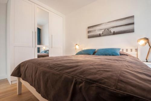 ミエンジズドロイェにあるBalticsand - Apartamenty nad morzemのベッドルーム1室(ブラウンの毛布を使用したベッド1台付)