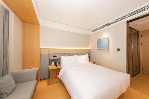 a hotel room with a bed and a couch at JI Hotel Gu'an Daxing International Airport in Dongsunguo