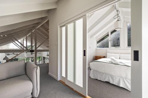 a bedroom with a bed and a couch and windows at Saltwood House NEW Listing in Gnarabup