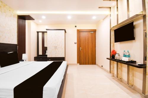 a hotel room with a bed and a flat screen tv at Super Townhouse Puri Formerly Hotel Narashingha in Puri