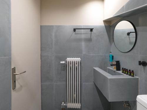 a bathroom with a sink and a white radiator at Spa Guest House by White Hills in the Heart of Arachova in Arachova