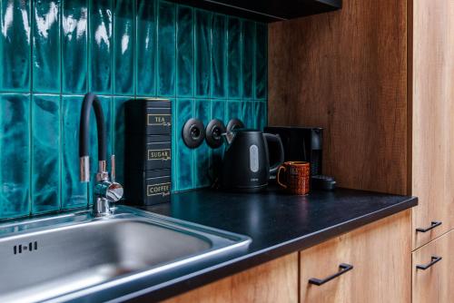 Una encimera de cocina con fregadero y microondas. en Vista Apartments Długa, en Bydgoszcz