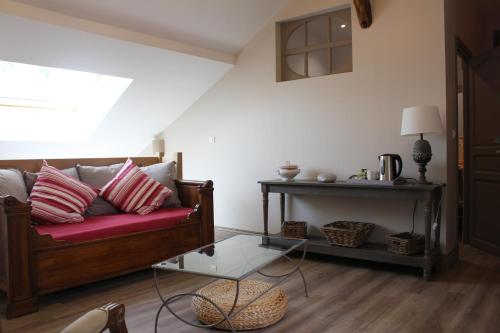 un salon avec un canapé rouge et une table dans l'établissement Ferme de la Vallière, à Tancrou