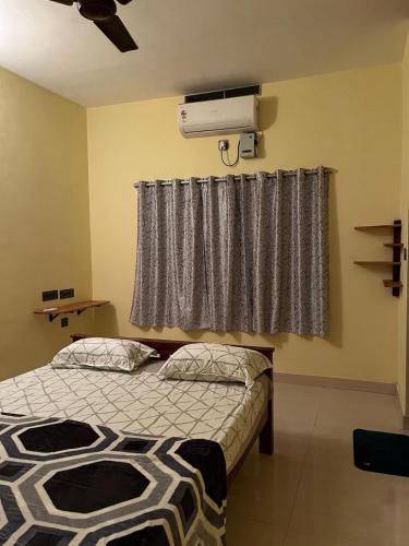 a bedroom with a bed and a air conditioner at Paradise Of Ross in Ernakulam