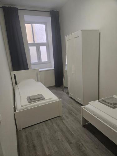 a small room with two beds and a window at Prater Apartments in Vienna