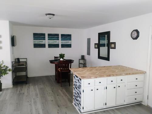 a white room with a table and a white dresser at Buskey's Cozy Haven in Williamsburg