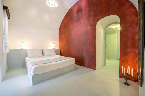 a bedroom with a bed with a red wall at Kalitsi Canaves in Vóthon
