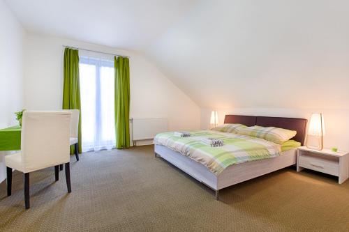 a bedroom with a bed and a desk and a chair at Aparmány² in Frymburk