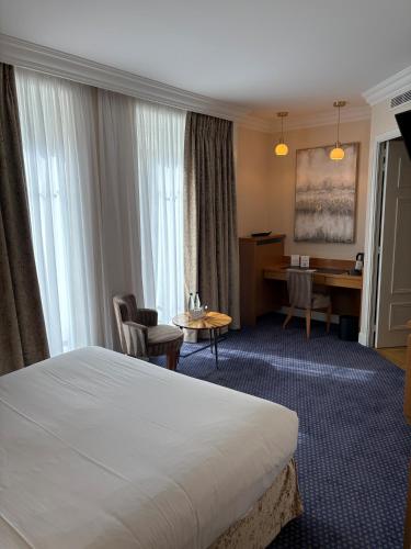 a hotel room with a bed and a desk at Maison LUTETIA R in Strasbourg