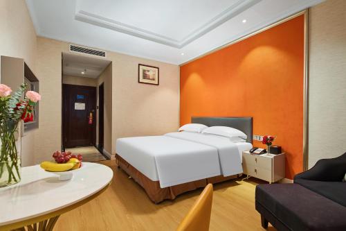 a bedroom with a bed and a table in a room at Quanzhou West Street Wanda Plaza Urbain Hotel in Quanzhou