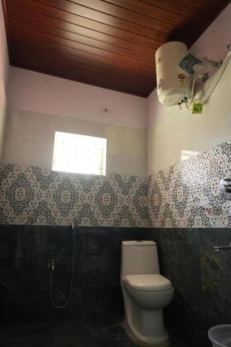 a bathroom with a toilet and a window at Meadow Resorts in Vythiri