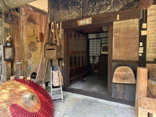 an entrance to a building with a red umbrella at 木古里ゲストハウス Kicoli guesthouse in Chizu