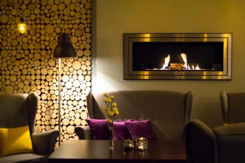 a living room with a fireplace and a table at Dwa Potoki in Karpacz