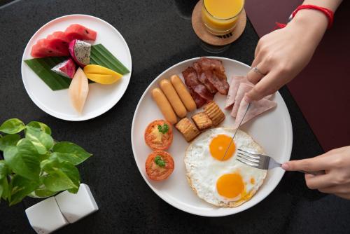a table with two plates of breakfast food on it at Koulen Central Hotel in Siem Reap